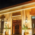 Illuminated entrance of Adoro Hotel Boutique at night