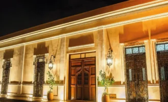Illuminated entrance of Adoro Hotel Boutique at night